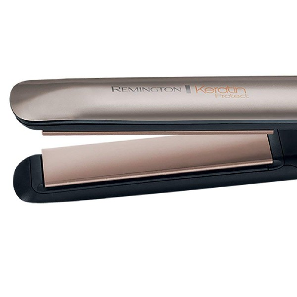 Una plancha para el cabello con un mango negro y placas doradas. Está cerrada.