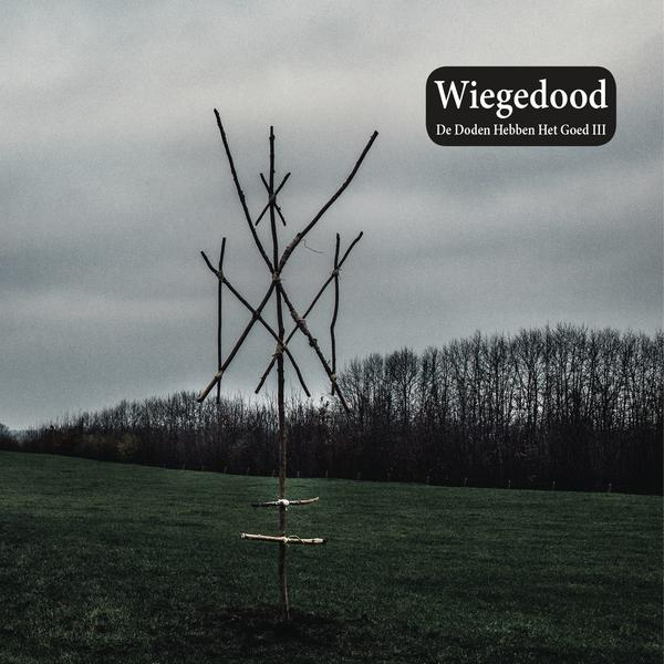 Albumcover von Wiegedood. Ein Baum aus Ästen auf einem Feld. Bewölkter Himmel.