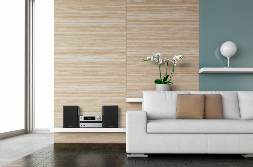 Moderne woonkamer met witte bank, houten panelen en decoratieve elementen.