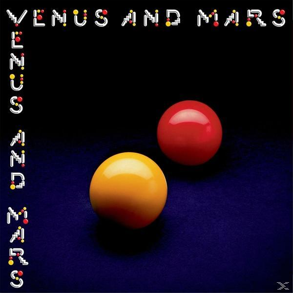 Zwei glänzende Kugeln, rot und gelb, auf dunkler blauer Oberfläche.