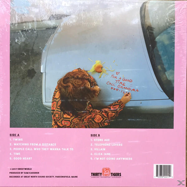 Ein rosa Albumcover mit Foto eines Autos und einer Person, die darauf schreibt. Titelliste links.