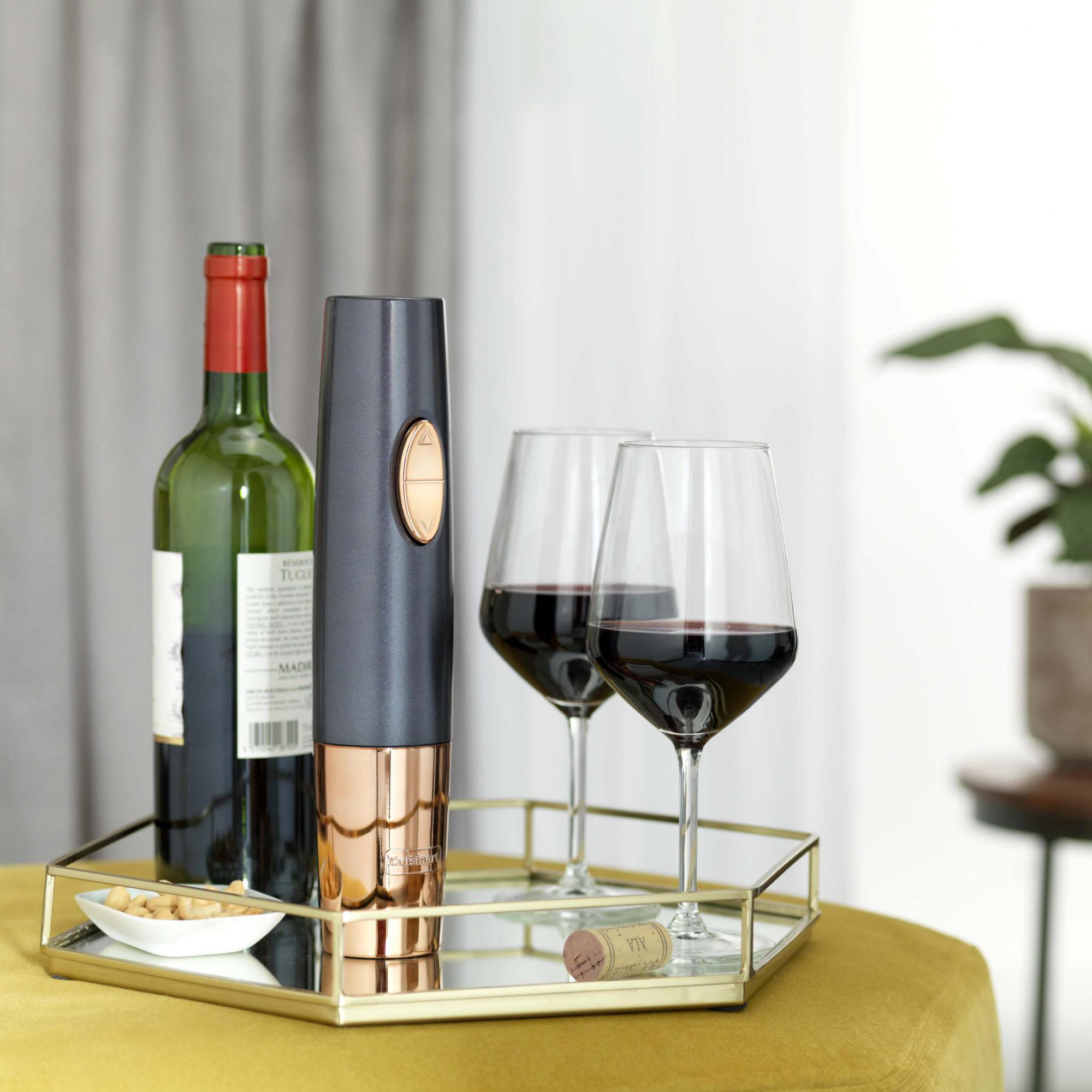 Weinflasche, elektrischer Korkenzieher, zwei Weingläser mit Rotwein und ein Korken.