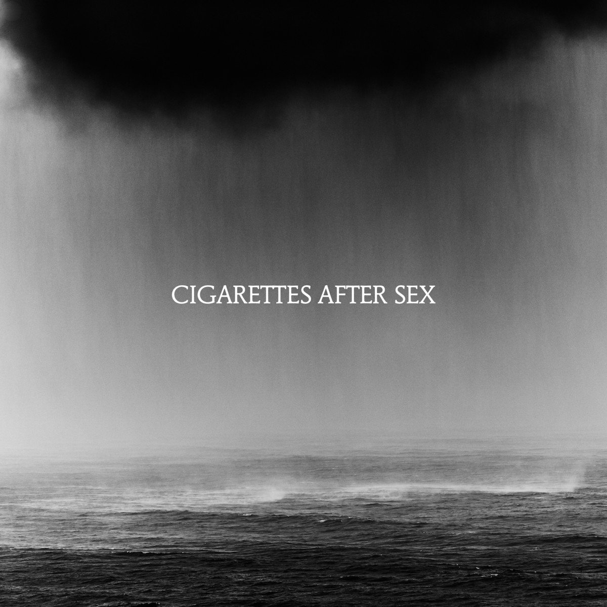 Pochette de l'album Cigarettes After Sex. Ciel couvert au-dessus de l'eau, texte blanc.