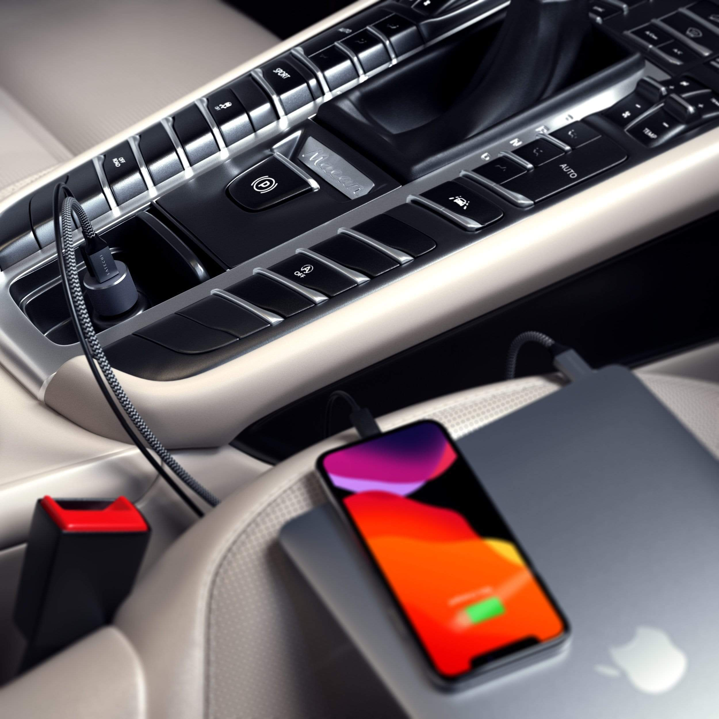 Interni auto con telefono e laptop in carica. Dettagli neri e argento. Sedili bianchi.