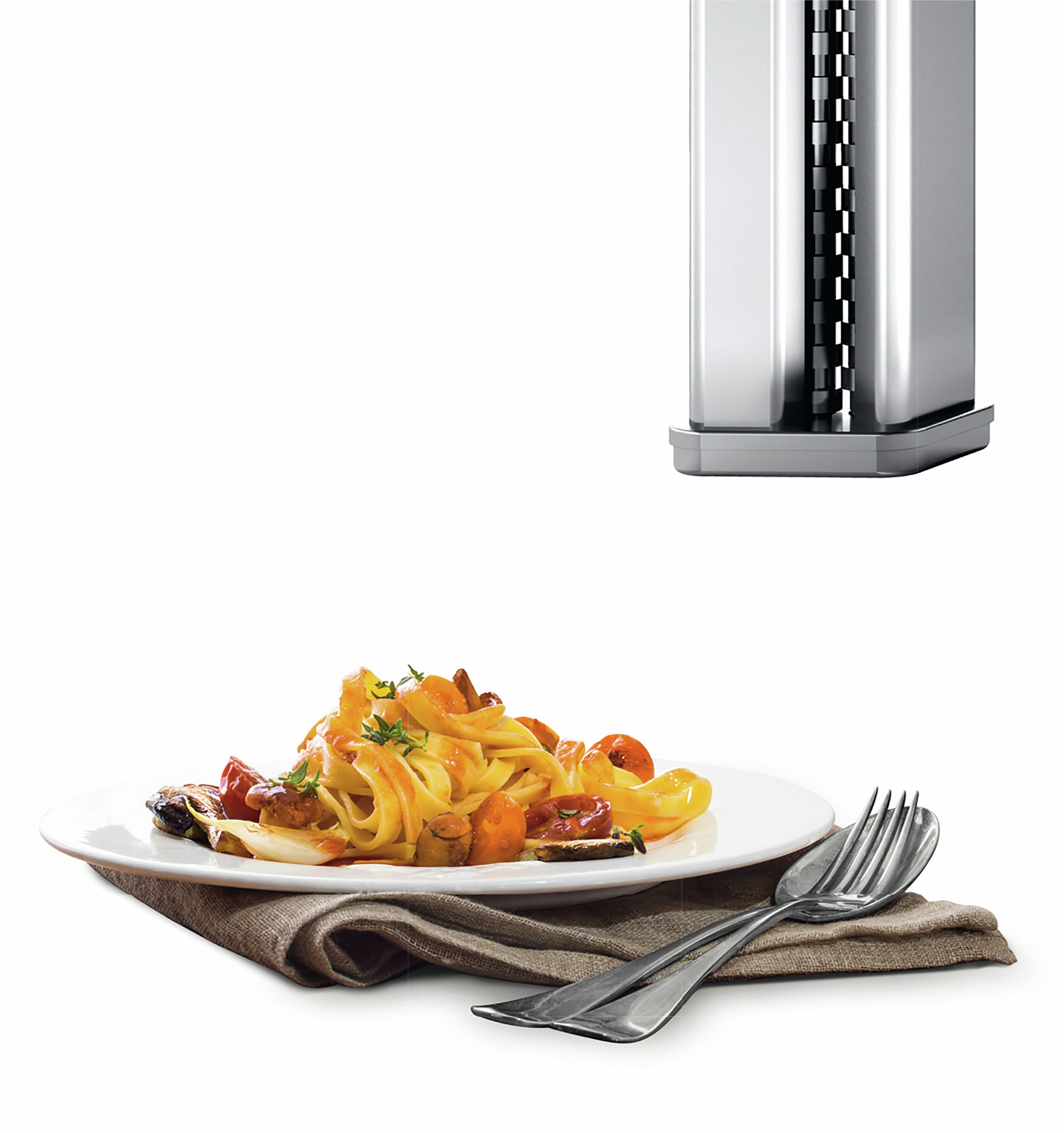 Fettuccine tészta zöldségekkel és ezüst evőeszköz készlet barna ruhán.