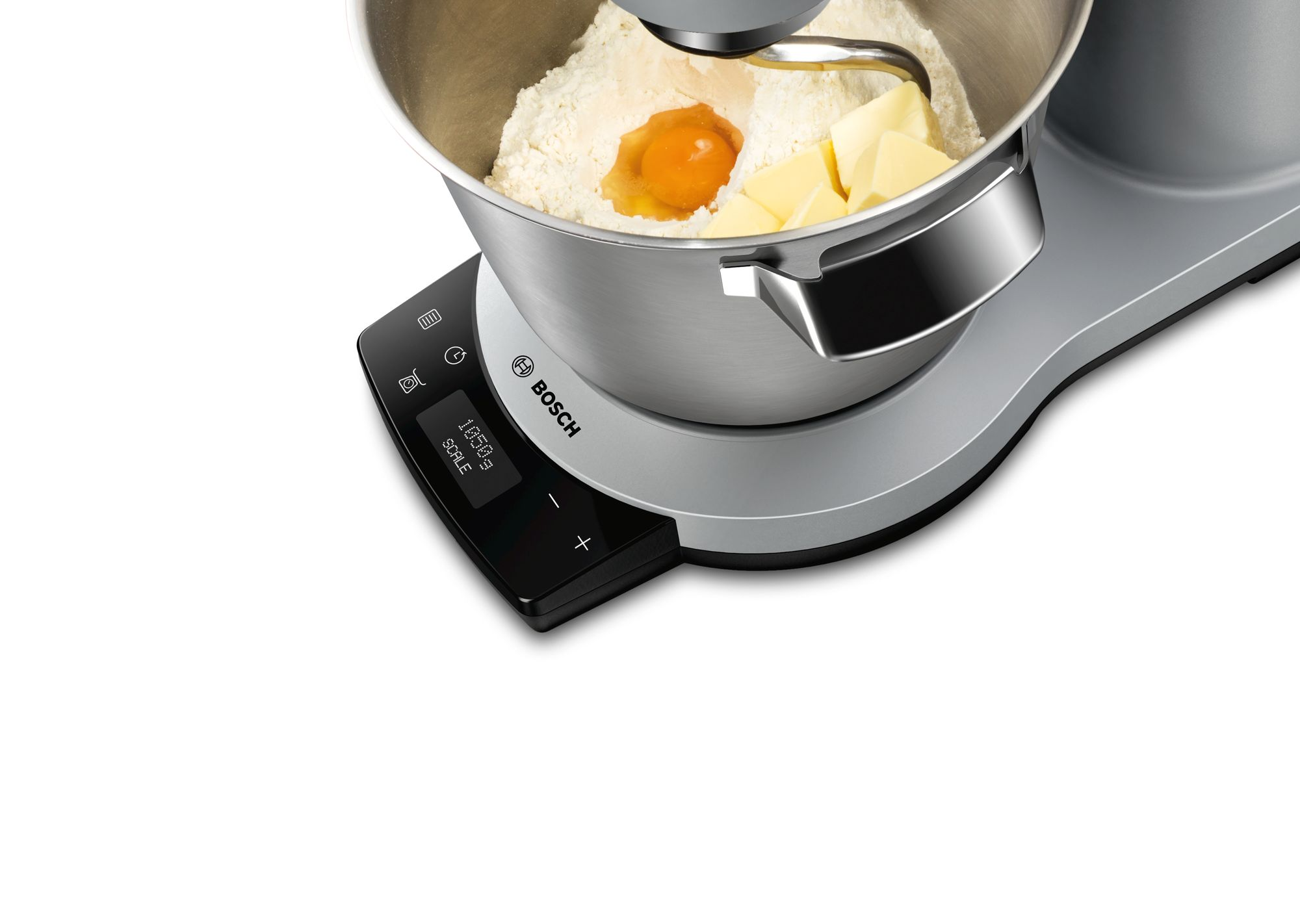 Egy mixer összetevőkkel. A tál lisztet, tojást és vajat tartalmaz.