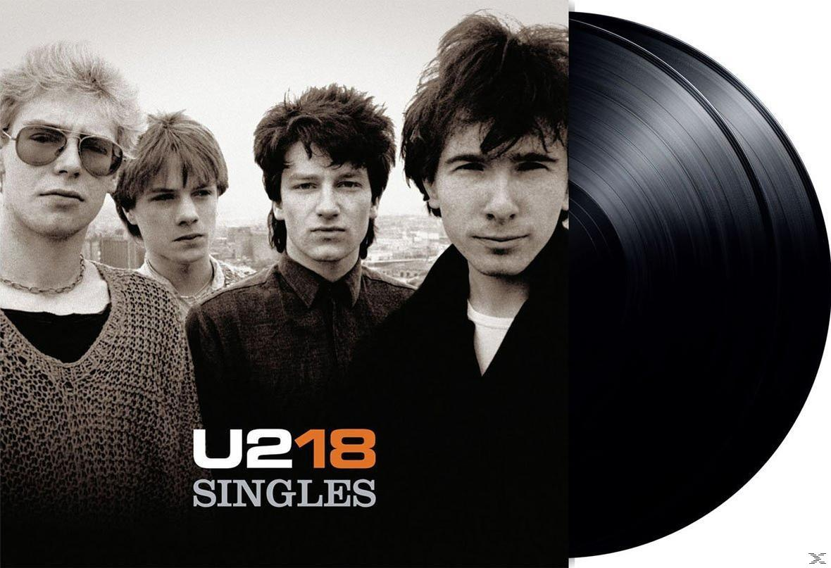 U2-Albumcover mit Bandmitgliedern und einer Vinyl-Schallplatte.