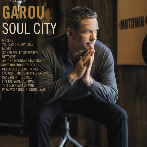 Pochette d'album : Garou, un homme en chemise grise, regardant sur le côté, les mains jointes.