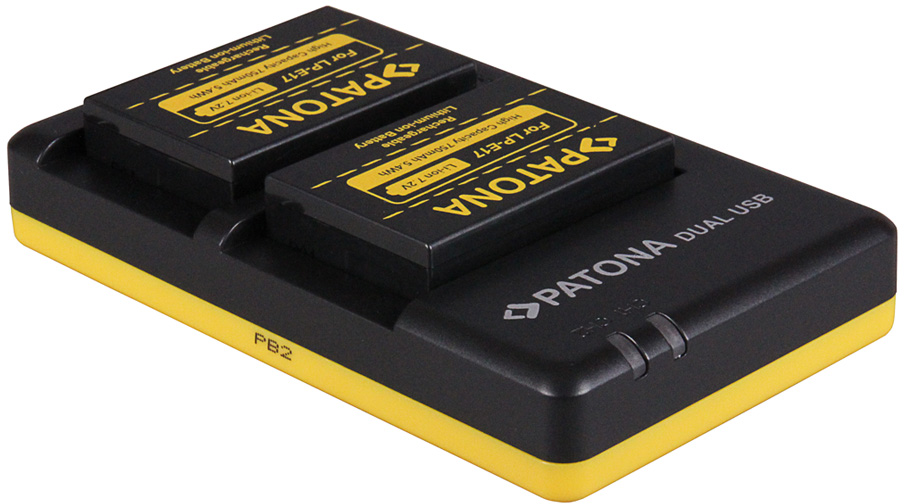 Deux batteries noires avec étiquettes jaunes sur un chargeur noir et jaune.