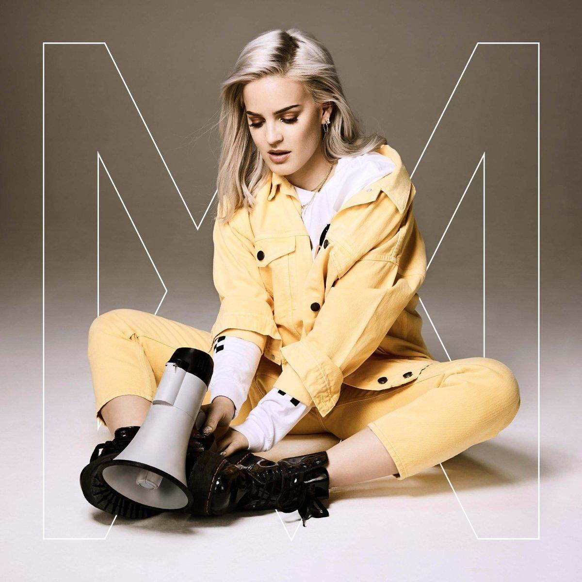 Albumcover: Anne-Marie sitzt, gelb gekleidet, hält ein Megaphon. Weißer Hintergrund, großer weißer Buchstabe M.