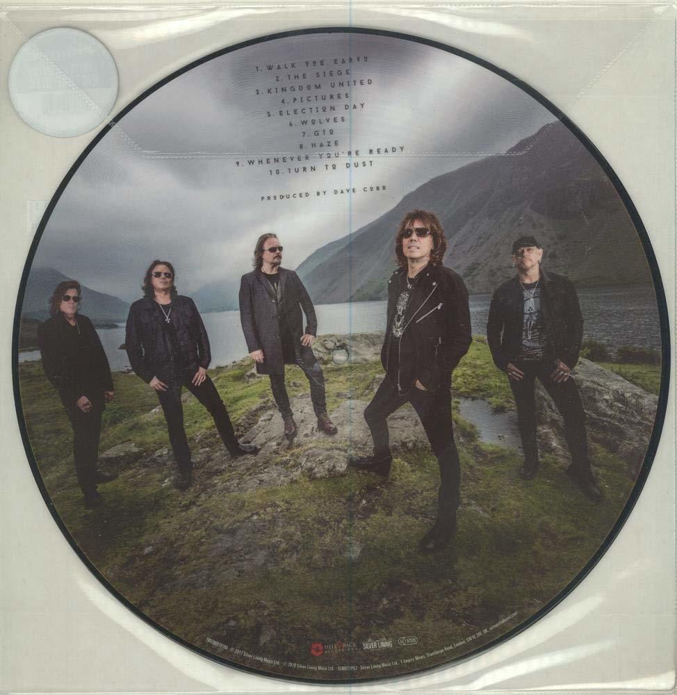 Eine CD mit Bandfoto und Songtiteln, Berge im Hintergrund.