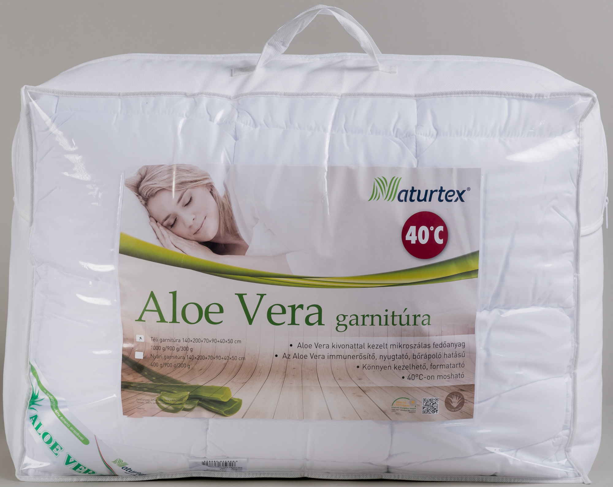 Fehér paplanhuzat átlátszó csomagolásban. Egy nő képe az „Aloe Vera” szöveggel az elején.