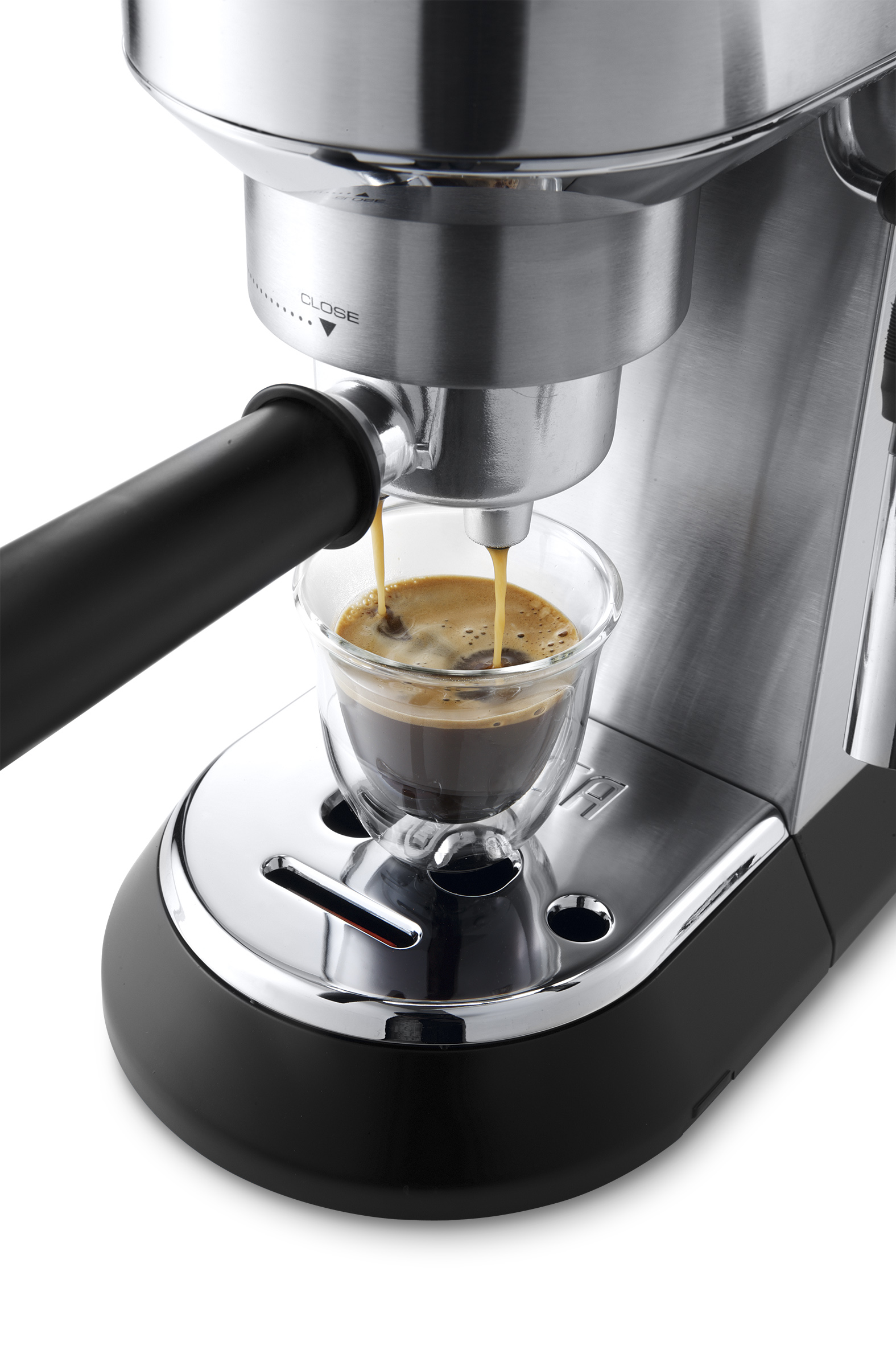 Espressomaschine gießt Kaffee in ein Glas. Schwarzer Sockel mit Chromfinish. Kaffee ist dunkelbraun.