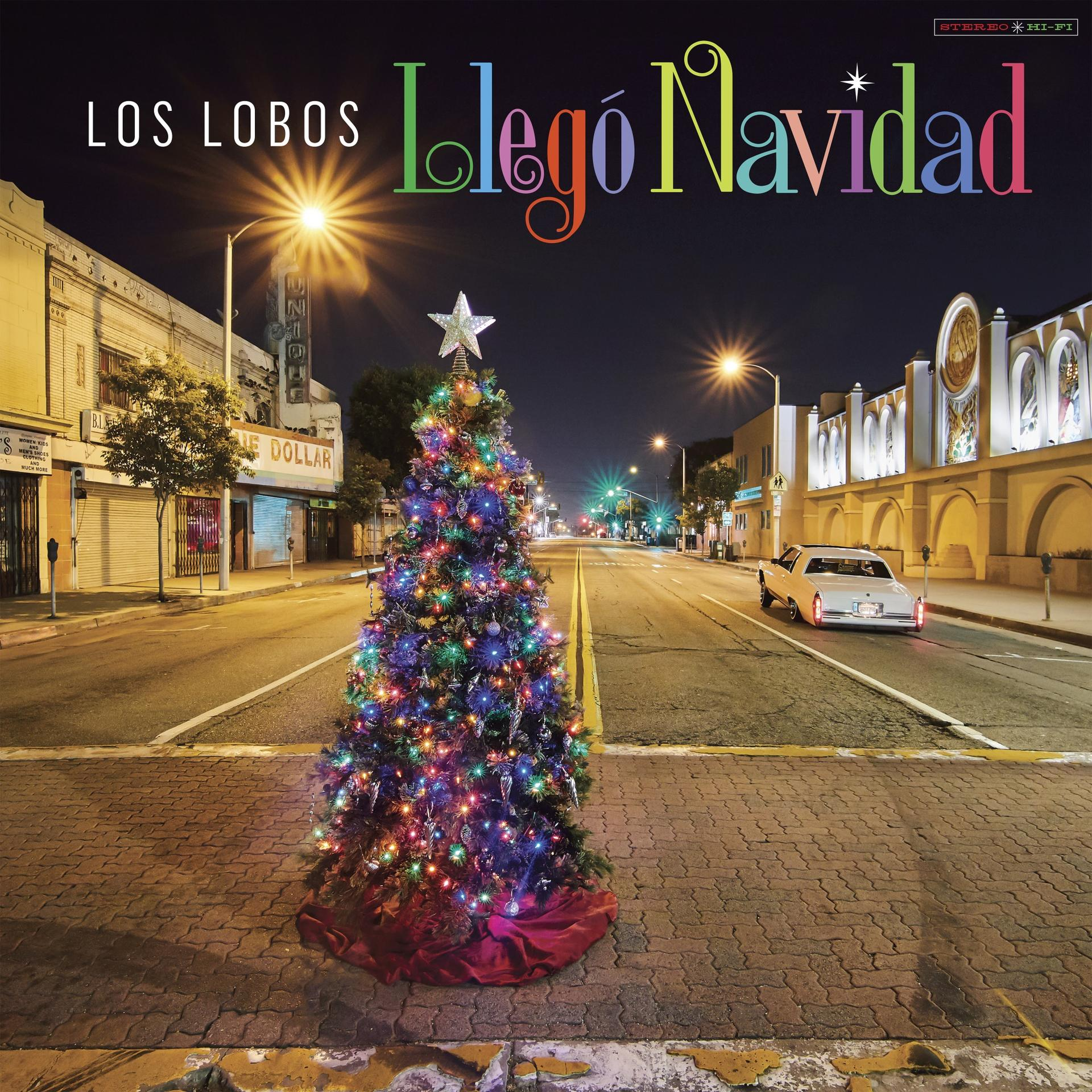 Albumhoes: Los Lobos, kerstboom midden op straat 's nachts, met een auto.