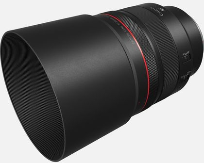 Un objectif d'appareil photo Canon noir avec un anneau rouge. Il a un pare-soleil attaché.