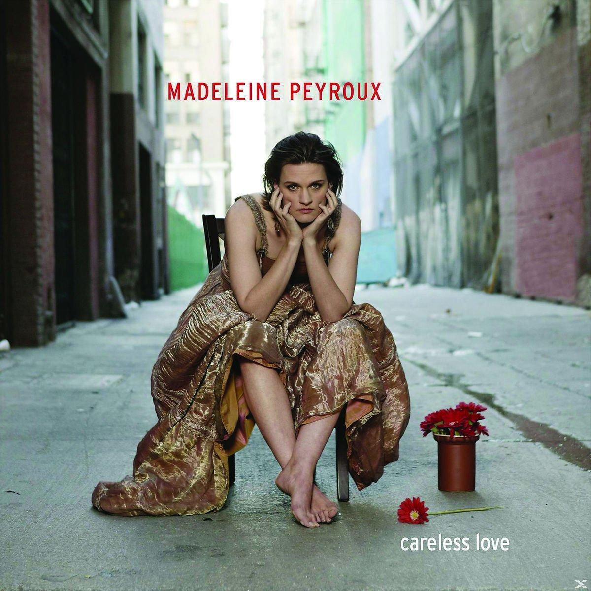 Albumcover mit Madeleine Peyroux, die in einer Gasse auf einem Stuhl sitzt. Sie trägt ein goldenes Kleid.