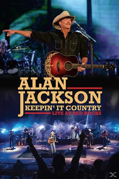 Alan Jackson live in den Red Rocks, mit Gitarre und Band im Hintergrund.