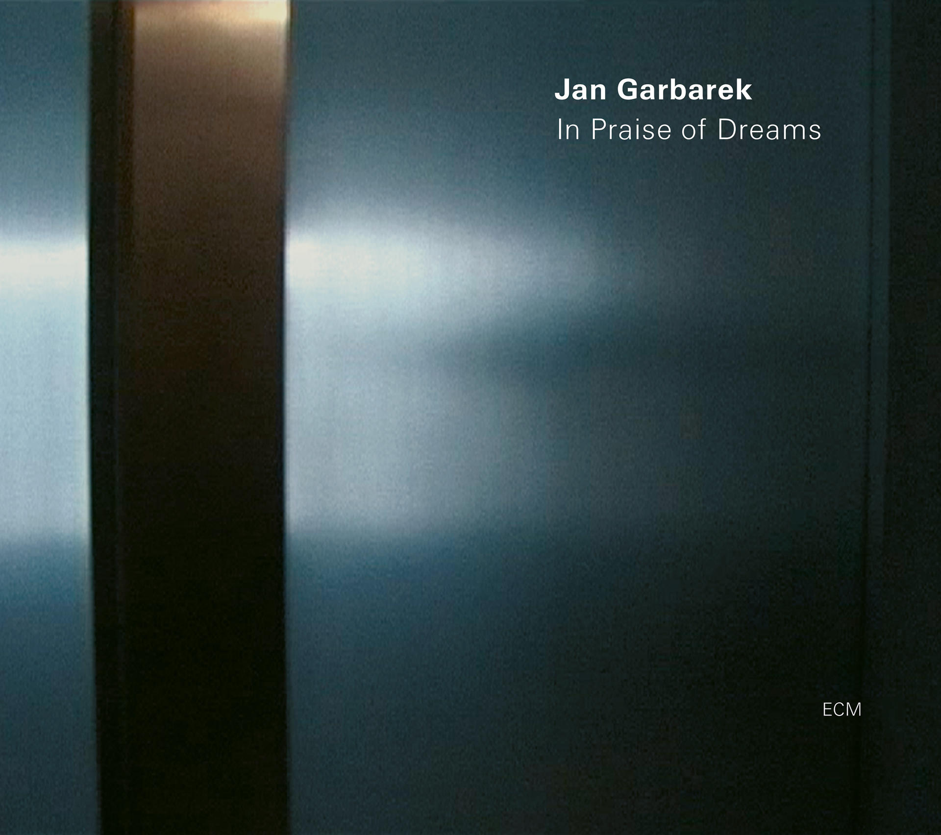 Egy CD borító kék és szürke dizájnnal. Szöveg van rajta, 'Jan Garbarek' és 'In Praise of Dreams' felirattal.