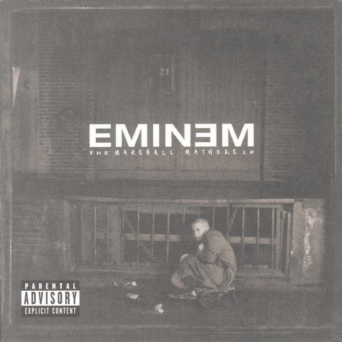 Eminem-Albumcover. Er hockt vor einem Gebäude. Der Albumtitel ist sichtbar.