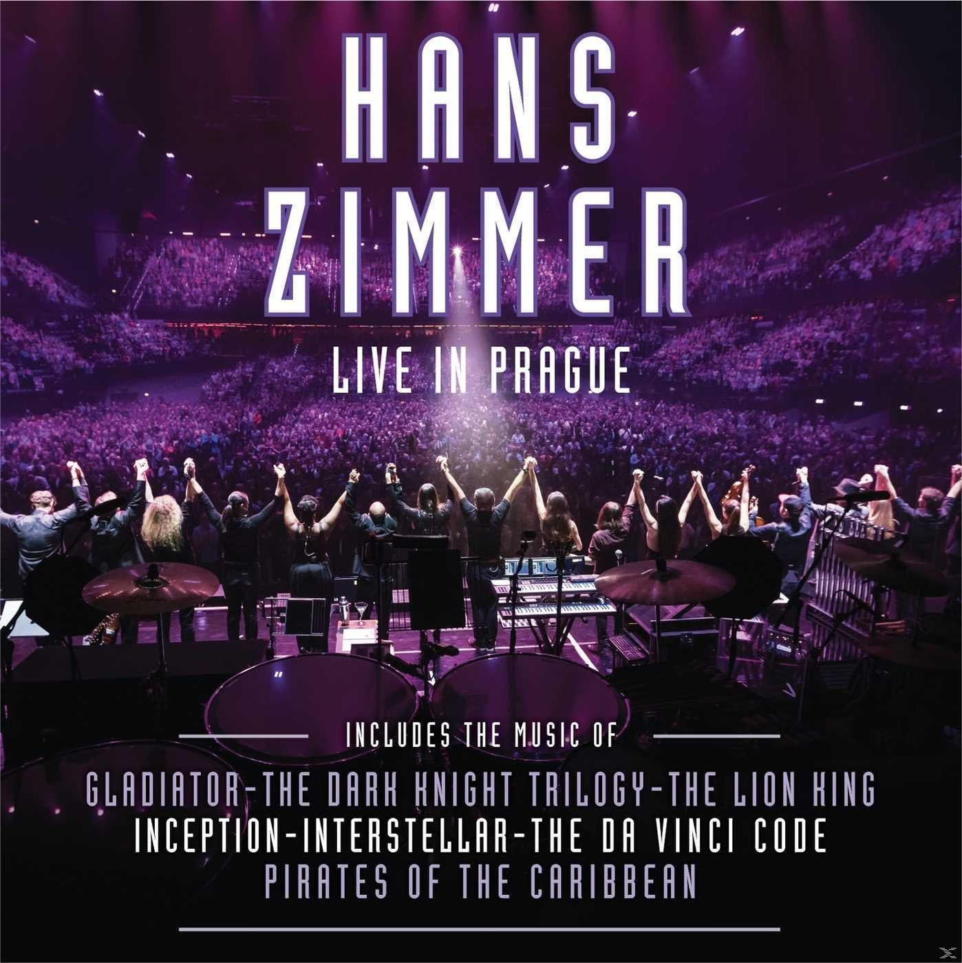 Hans Zimmer concert, muzikanten op het podium, publiek op de achtergrond, paarse verlichting.