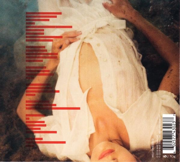 Femme en robe blanche allongée sur une surface avec des lignes rouges. L'accent est mis sur son visage et sa poitrine.