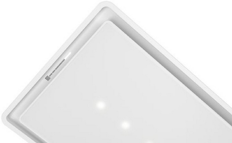Primer plano de la esquina superior de una luz de techo blanca empotrada con tres luces.