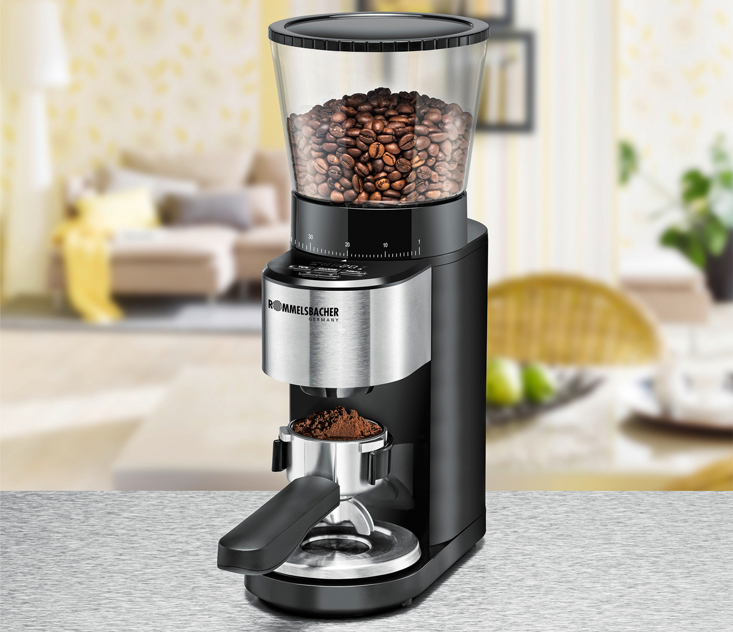 Schwarze und silberne Kaffeemühle mit Kaffeebohnen im oberen Behälter und gemahlenem Kaffee im Siebträger.