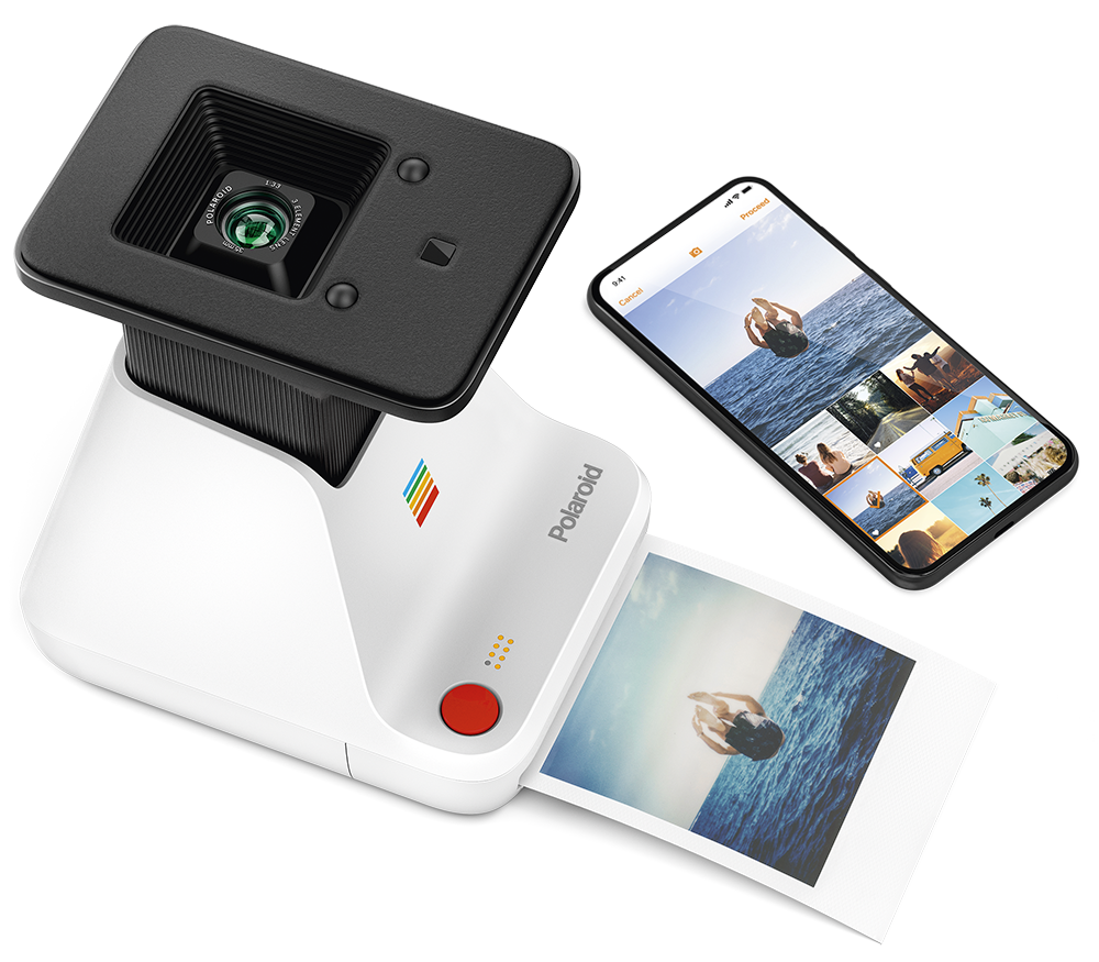 Polaroid camera and phone displaying images. A printed photo on the surface.