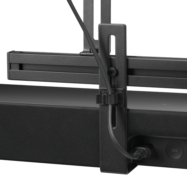 Zwarte soundbar met een kabelmanagementclip bevestigd, tegen een witte achtergrond.