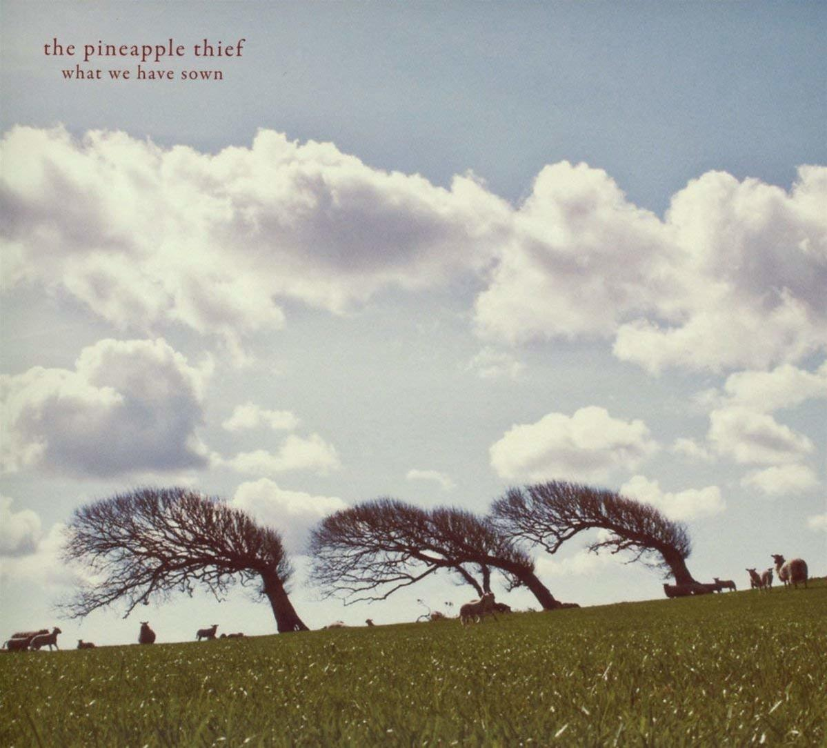 Albumcover: The Pineapple Thief. Bäume auf einem Hügel mit Schafen, Wolkenhimmel im Hintergrund.