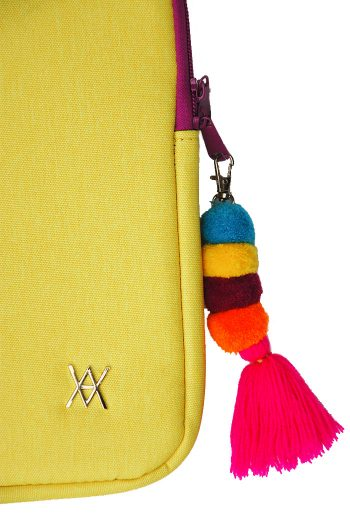 Funda amarilla para portátil con cremallera morada y borla multicolor.