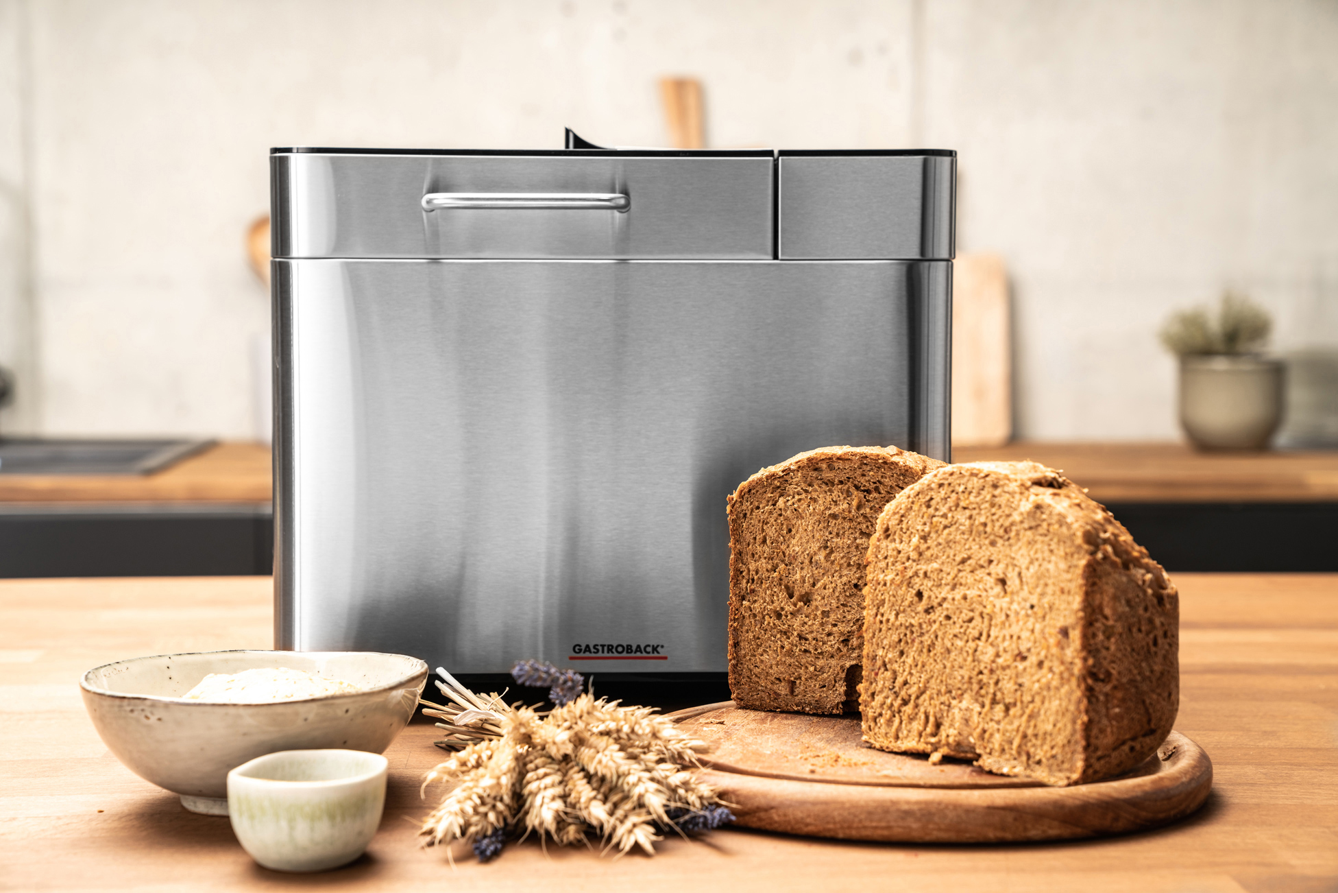 Ein Brotbackautomat aus Edelstahl mit zwei Brotscheiben und Zutaten.