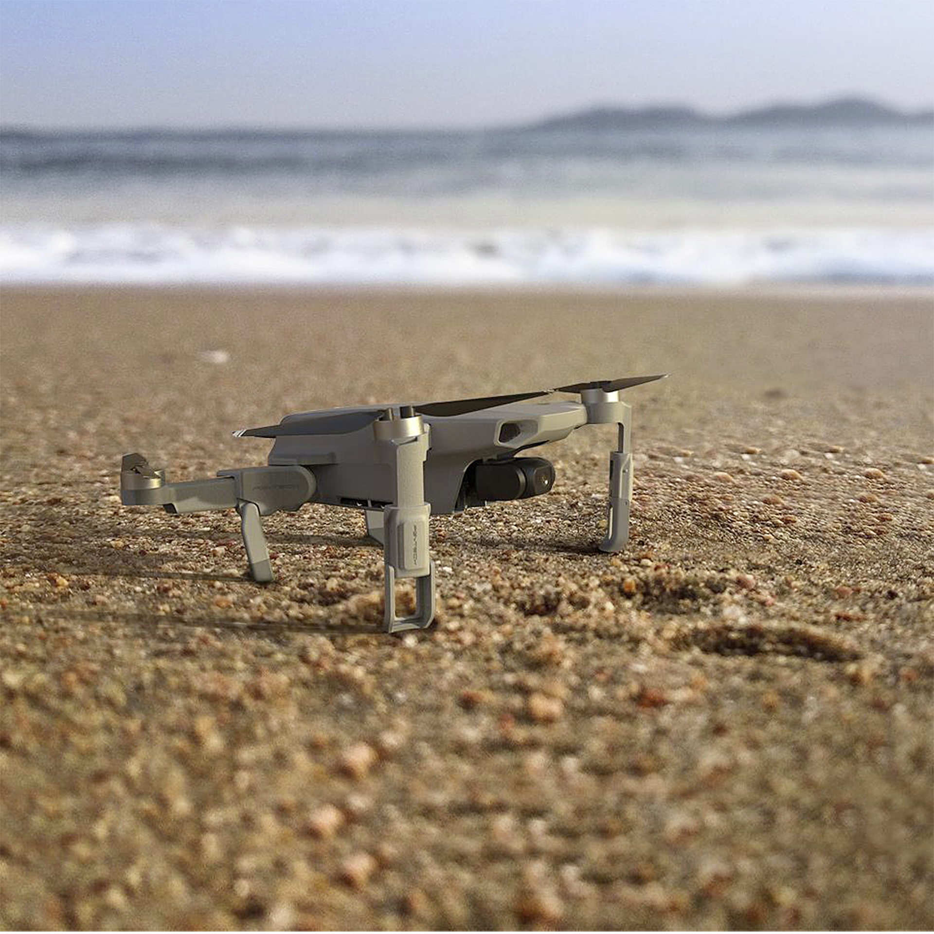 Eine graue Drohne am Strand mit dem Ozean im Hintergrund.