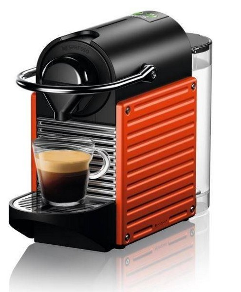 Cafetera Nespresso roja y negra, con un vaso de espresso en la bandeja.