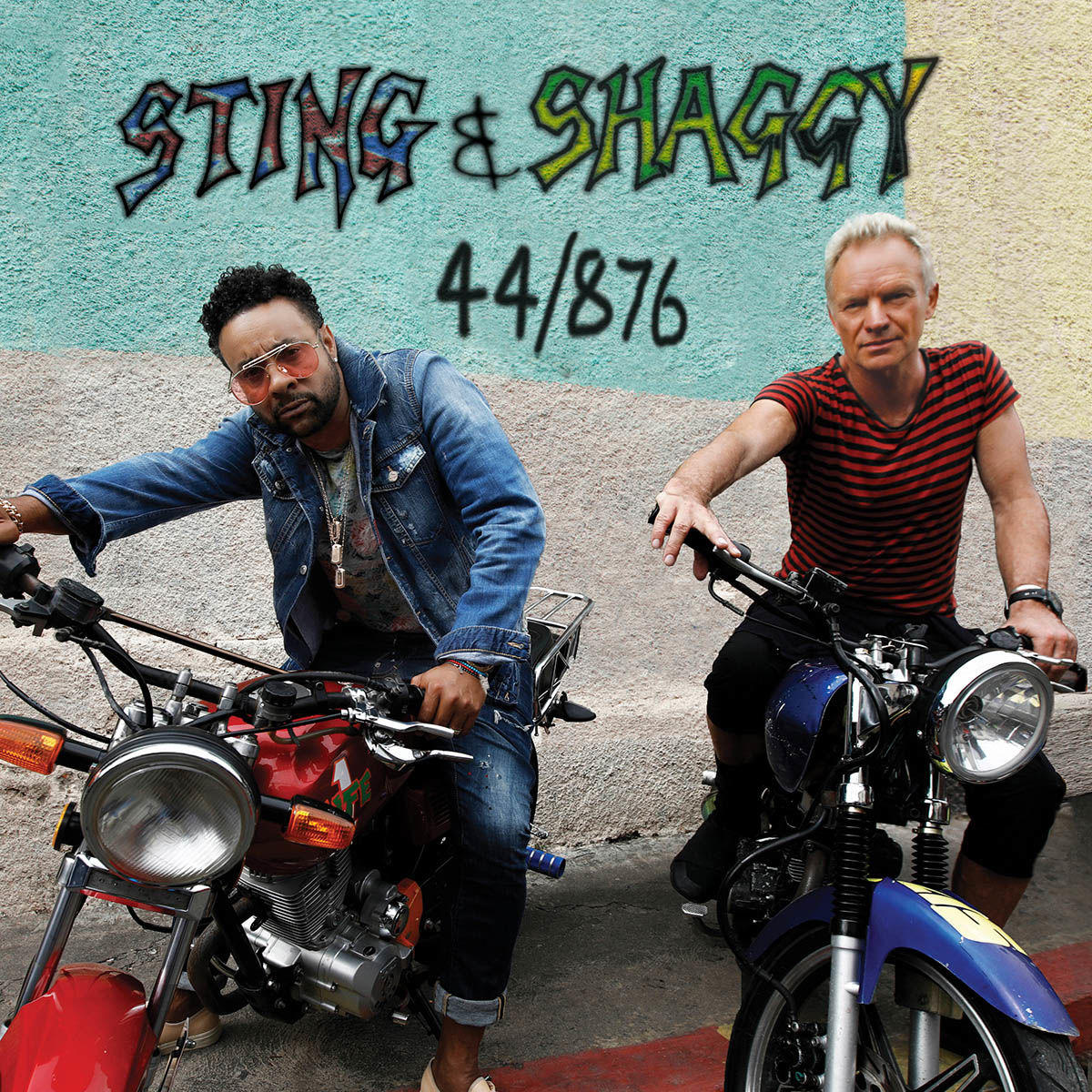 Sting und Shaggy auf Motorrädern, mit Graffiti im Hintergrund.