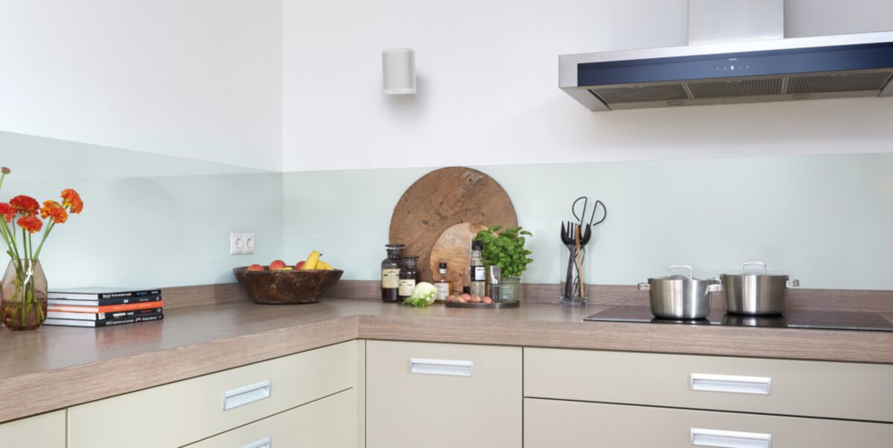 Cuisine moderne avec plan de travail en bois clair. Divers objets sur le comptoir.