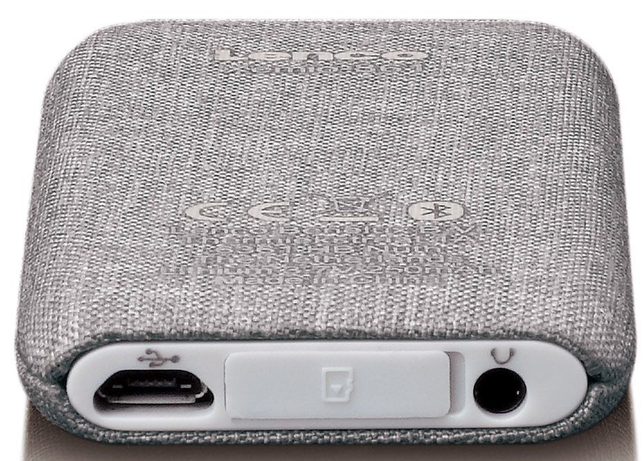Small gray fabric-covered device with ports for USB, microSD card, and headphones.