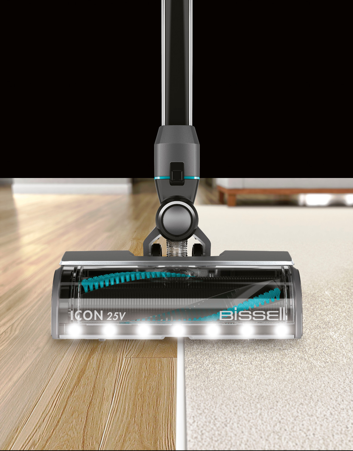Tête d'aspirateur, montrant une section de plancher en bois et de moquette. La brosse et les lumières sont visibles.