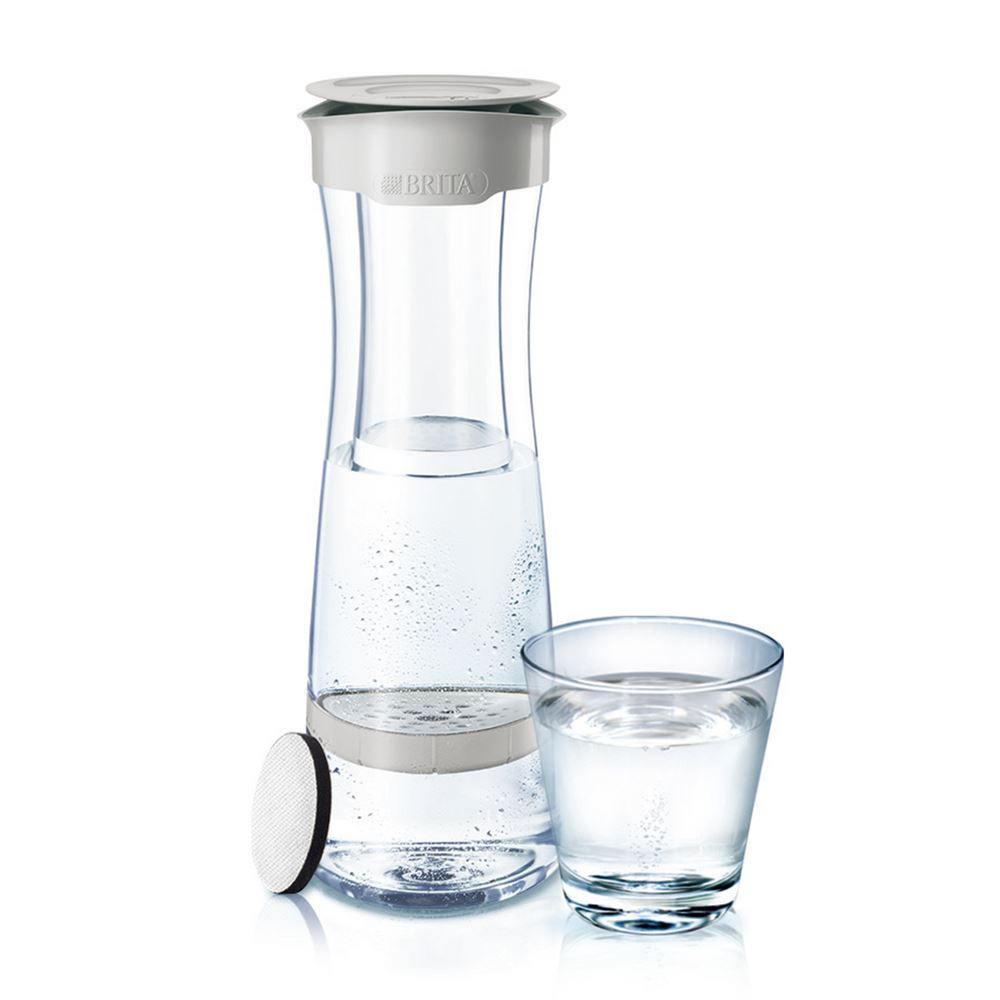 Brita water filter pitcher and a glass of water. The pitcher is transparent. White background.