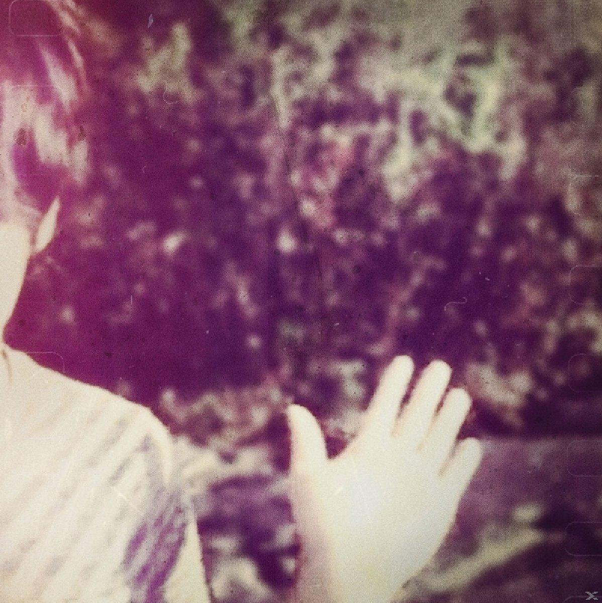 Verschwommenes Foto. Hand ausgestreckt. Gestreifter Hemdärmel sichtbar. Lila und grüner Hintergrund.