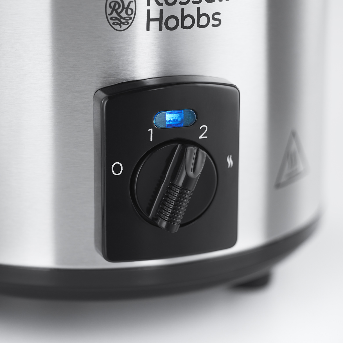 Close-up of a Russell Hobbs slow cooker control panel with a blue light indicating power.