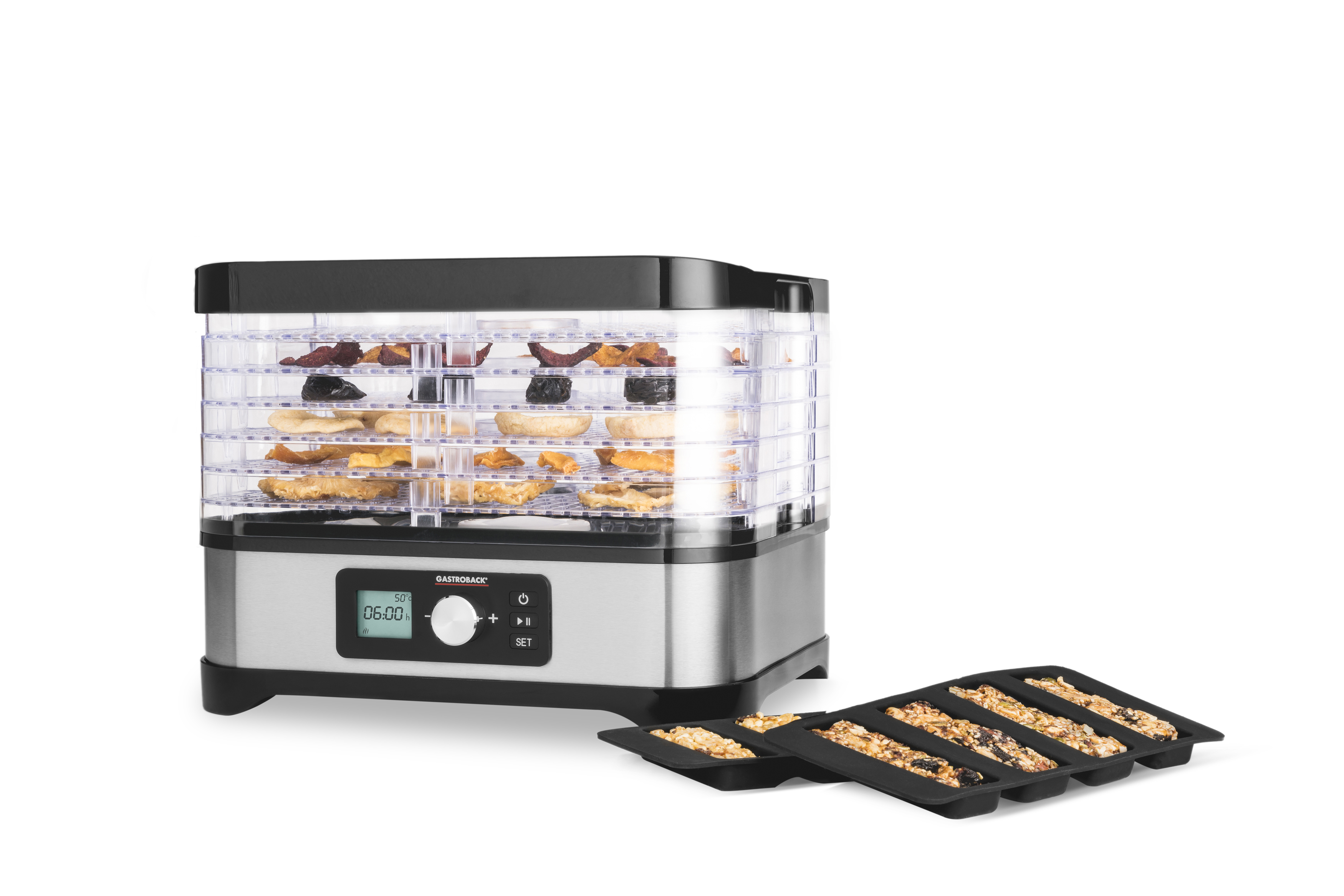 Ein Lebensmittel-Dehydrator mit getrockneten Lebensmitteln und einem schwarzen Tablett mit getrockneten Lebensmitteln auf weißem Hintergrund.