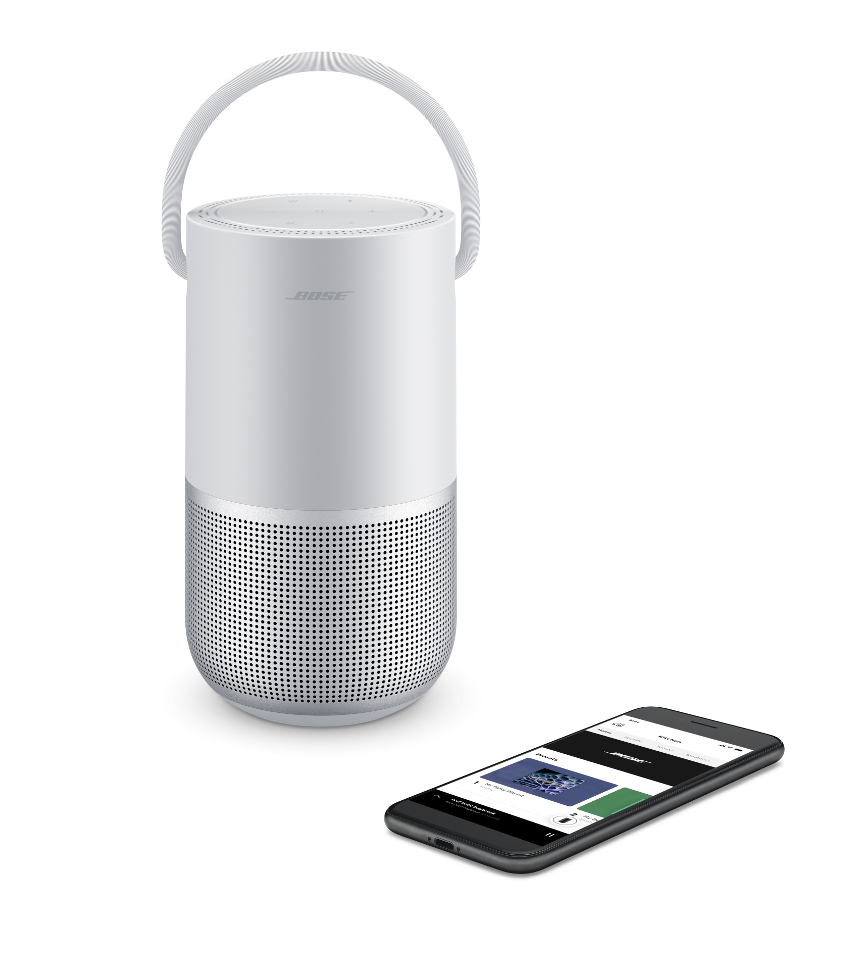 Ein weißer Bose-Lautsprecher und ein Telefon. Auf dem Telefon wird eine Musik-Streaming-App angezeigt.