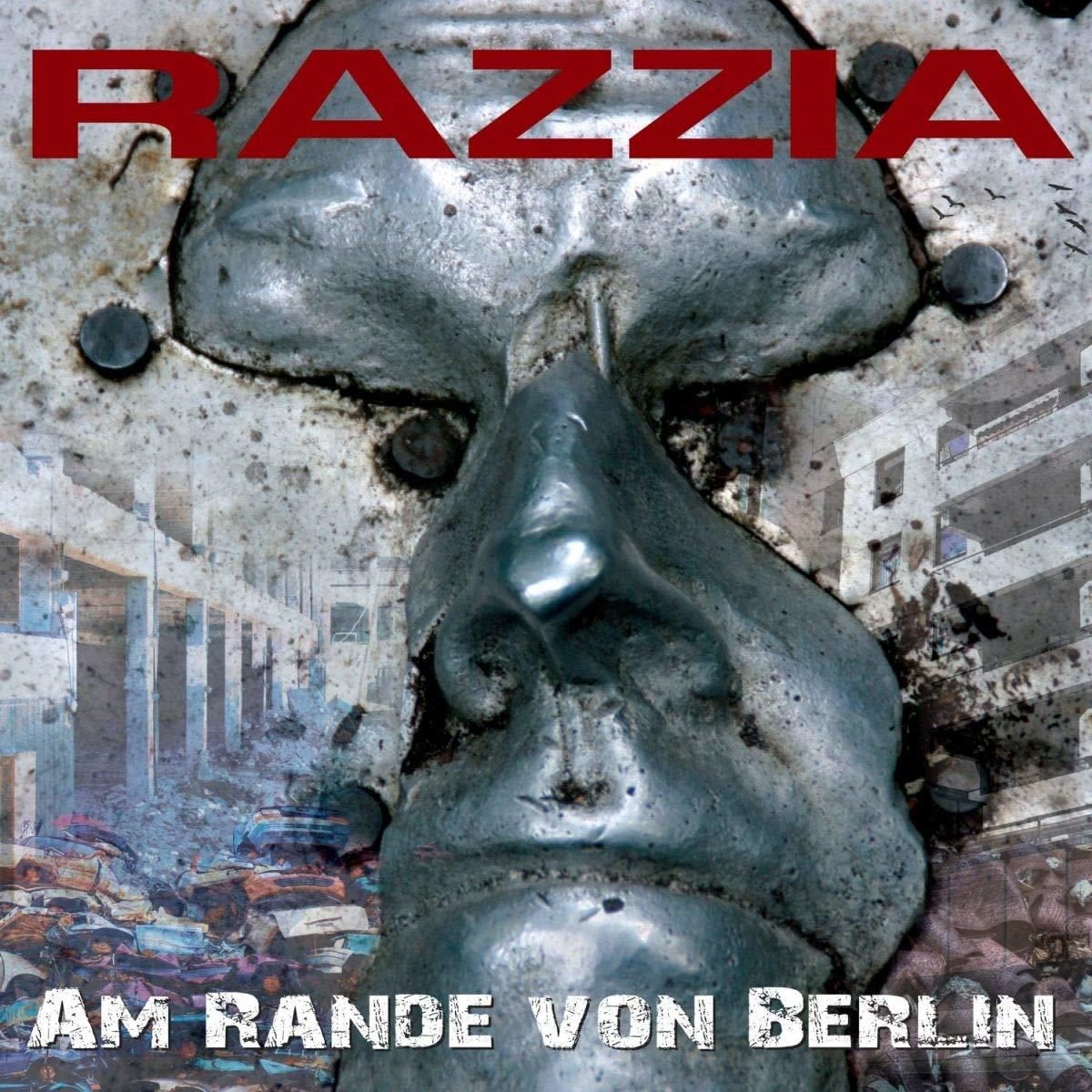 Albumcover mit einer Metallgesichtsskulptur und dem Text 'RAZZIA'. Hintergrund Gebäude und Trümmer.