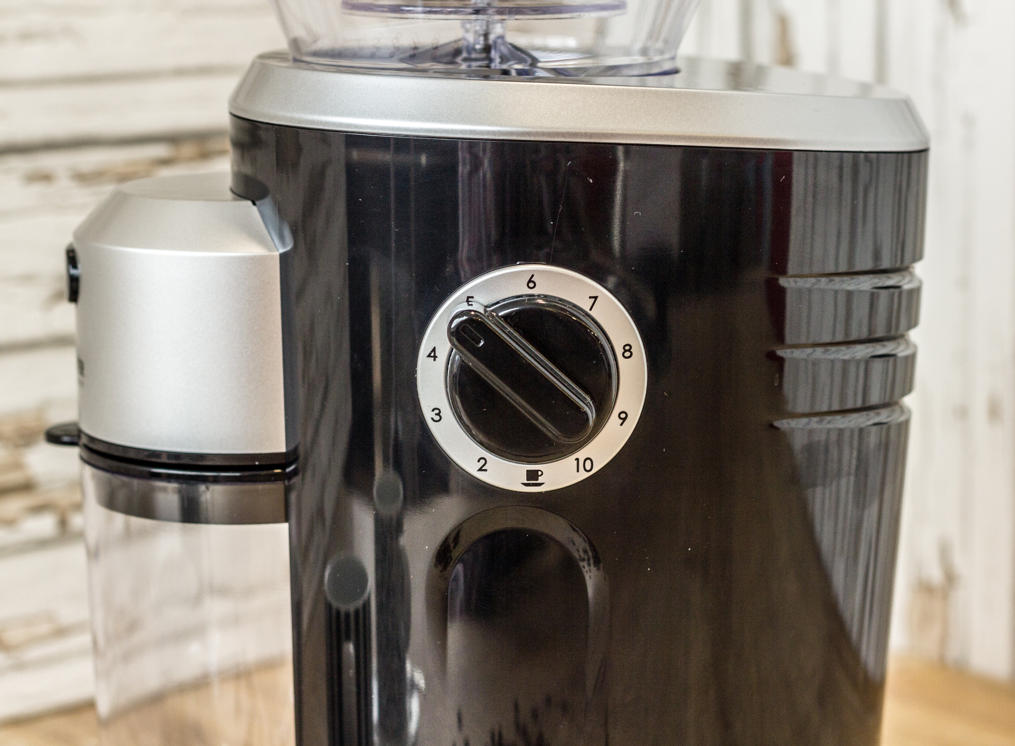 Eine schwarze Kaffeemühle mit einem transparenten Bohnenbehälter und Zahleneinstellungen.