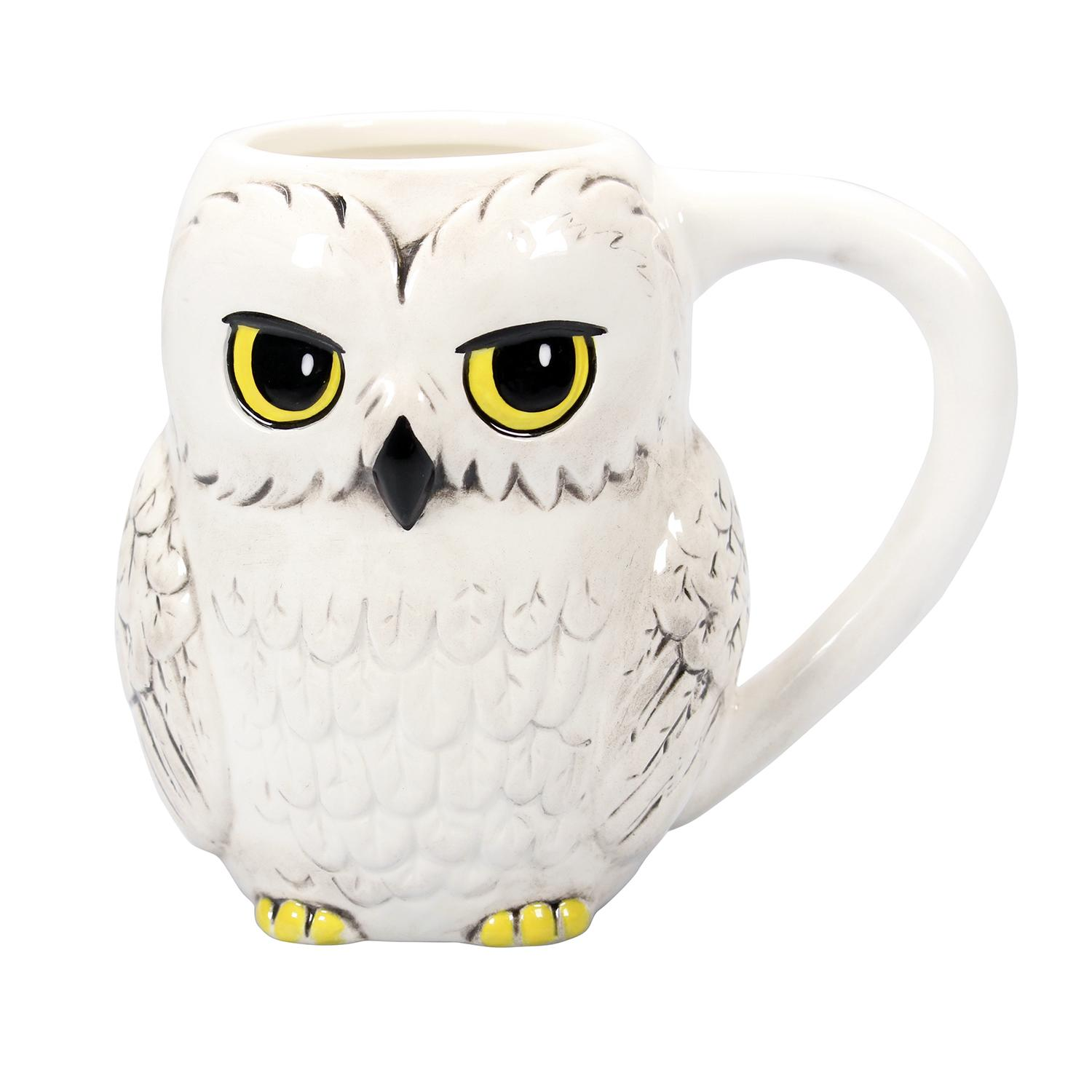 Eine eulenformige Tasse in Weiß mit gelben Augen und einem Henkel. Die Tasse steht vor weißem Hintergrund.