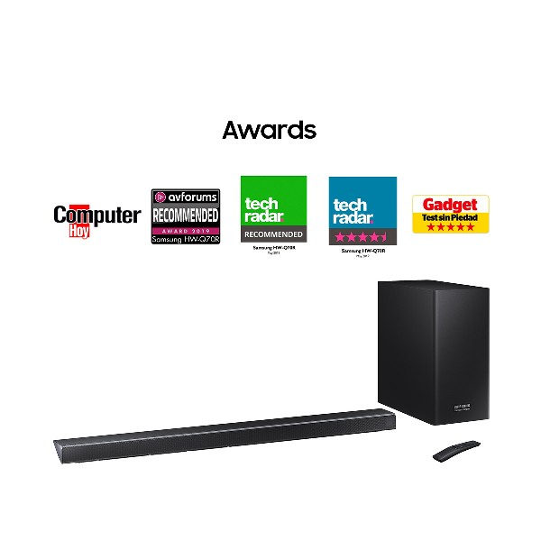 Una barra de sonido, subwoofer y mando con logotipos de premios sobre blanco.