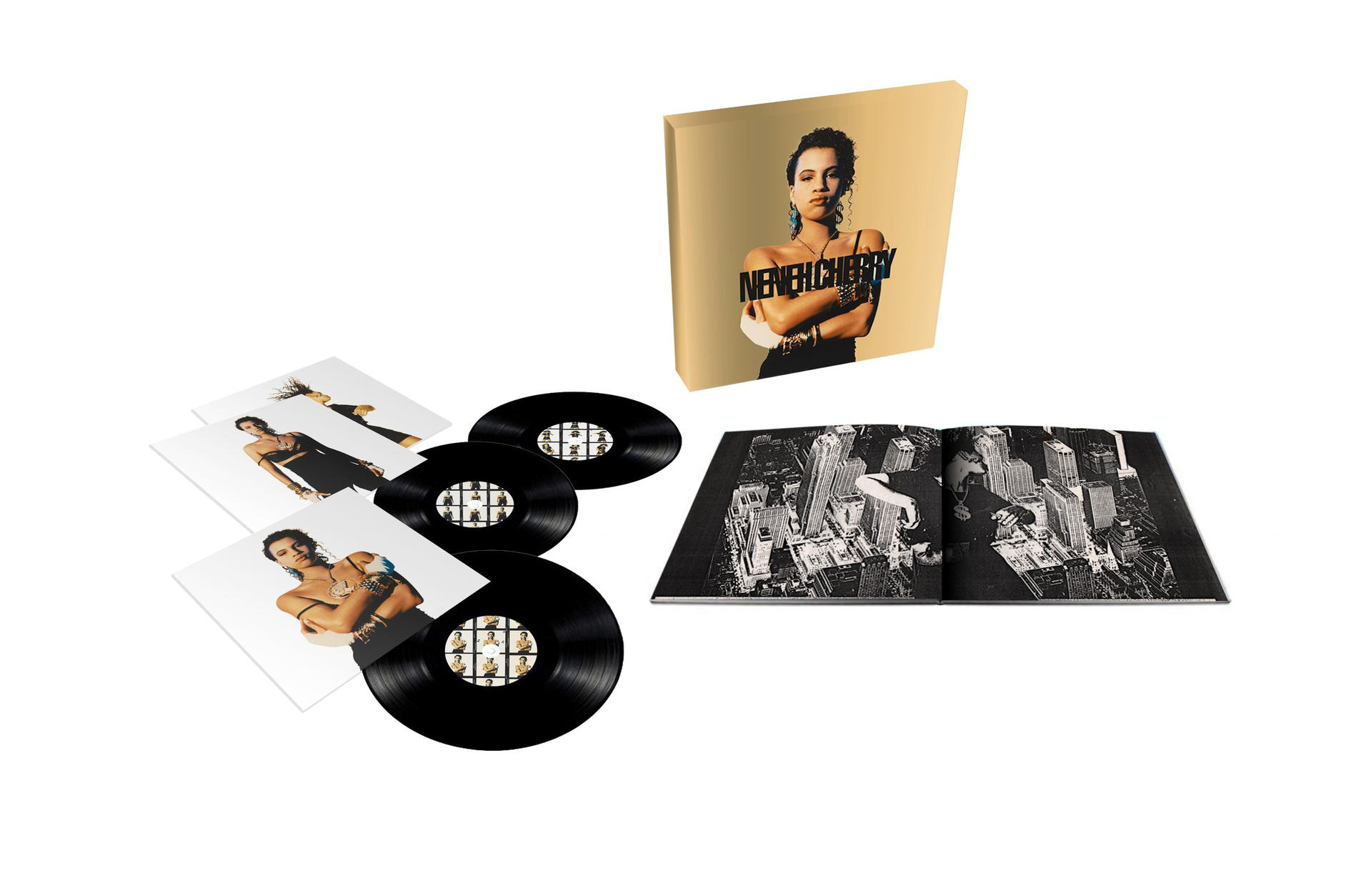 Un coffret avec albums et photos. Un album est ouvert montrant une image d'une ville la nuit.