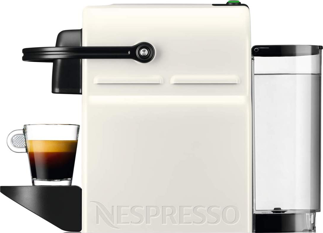 Macchina da caffè Nespresso color crema con una tazza di caffè e un contenitore d'acqua.