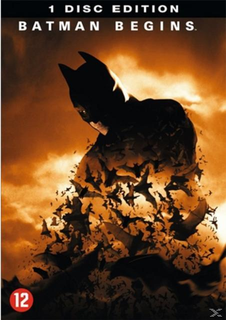 Batman-silhouet komt tevoorschijn uit een zwerm vleermuizen tegen een oranje, bewolkte hemel.